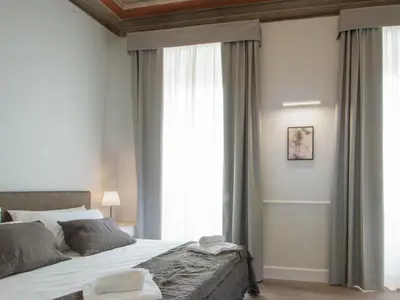 a bedroom with a bed and a large window at Gemini Suites Navona in Rome