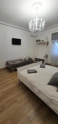 two beds in a room with a chandelier at Da Nonna Maria in Rome