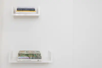 two shelves with books on a white wall at Trevi Fountain Apartment - ZENO 03 in Rome