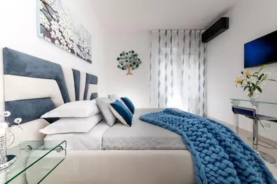 a bedroom with a bed with a blue blanket on it at St.Peter's Eden in Rome