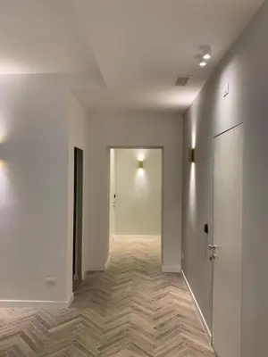 an empty hallway with white walls and wooden floors at Florea Palace in Rome