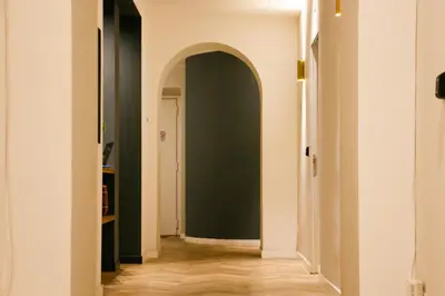 a hallway with a green wall and an archway at Florea Palace in Rome