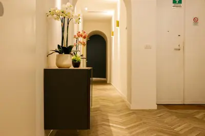 a hallway with a black cabinet with flowers on it at Florea Palace in Rome