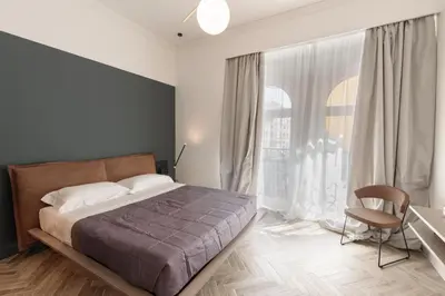a bedroom with a bed and a desk and a window at Florea Palace in Rome
