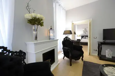 a living room with a fireplace and a vase of flowers at Easydomus Rome in Rome