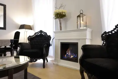 a living room with a fireplace and chairs at Easydomus Rome in Rome