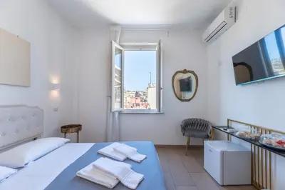 a white bedroom with a bed and a window at Art Atelier Vaticano Guest House in Rome