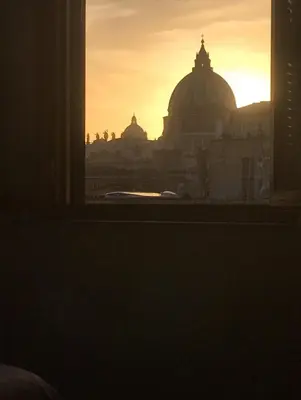 a view of a sunset from a window at Art Atelier Vaticano Guest House in Rome