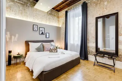 a bedroom with a large bed and a mirror at Tankara Suite in Rome