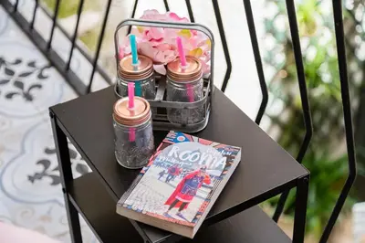 a table with a magazine and two bottles and a book at Tankara Suite in Rome