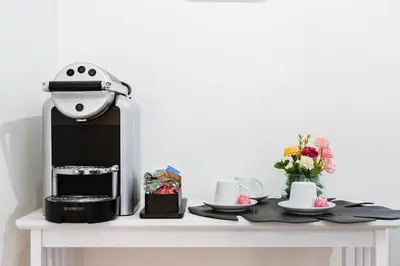 a table with a coffee machine on top of it at Tankara Suite in Rome