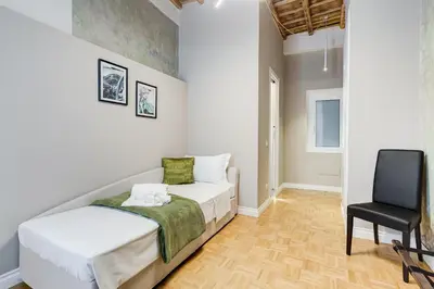 a bedroom with a bed and a chair at Tankara Suite in Rome