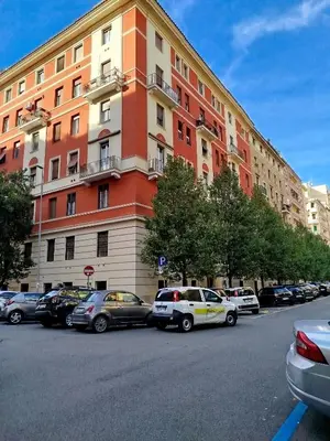 a large building with cars parked in a parking lot at Almachiara in Rome