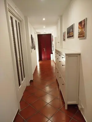 a hallway with a tiled floor and a red door at Almachiara in Rome