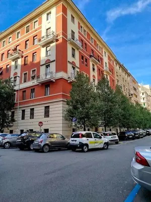 a large building with cars parked in a parking lot at Almachiara in Rome