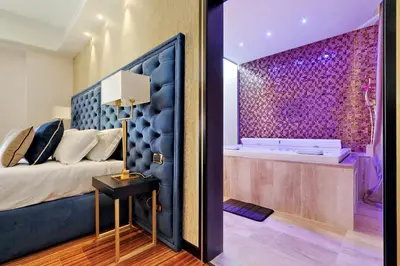 a bedroom with a large bed and a tub at Spanish Diamond Luxury Suites & Jacuzzi in Rome