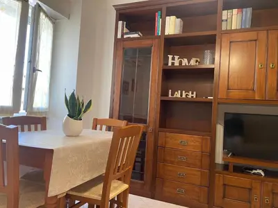 a dining room with a table and a entertainment center at Roma Apartment in Rome