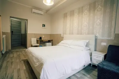 a bedroom with a white bed and a blue chair at Walker Rooms in Rome
