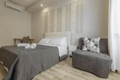 a bedroom with a bed and a chair at Walker Rooms in Rome