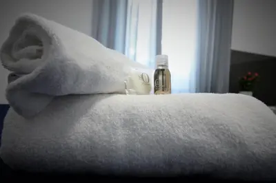 a bottle of alcohol sitting on a bed with a towel at AFFITTACAMERE A CASA MIA in Rome