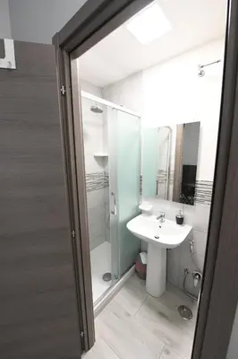 a bathroom with a white sink and a shower at AFFITTACAMERE A CASA MIA in Rome