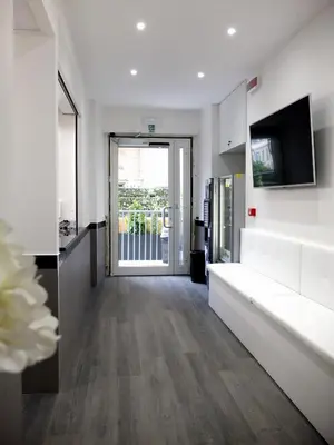 a corridor of an office building with white walls and wooden floors at ASTORIA GOLDEN GATE in Rome