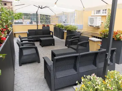 a patio with black chairs and an umbrella at ASTORIA GOLDEN GATE in Rome