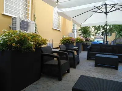 a patio with chairs and tables and an umbrella at ASTORIA GOLDEN GATE in Rome