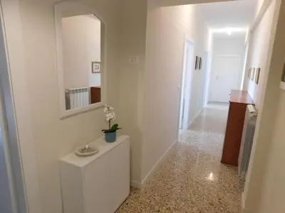 a hallway with a mirror and a cabinet with a plant on it at My House in Rome in Rome