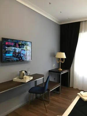 a room with a desk and a chair and a table at Unicum Roma Suites in Rome