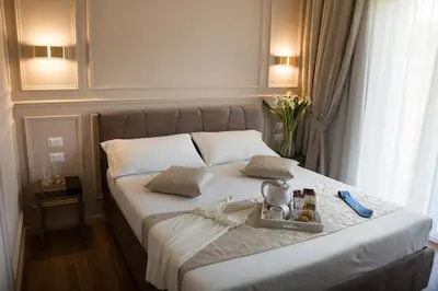 a bed with a tray of food on it at Unicum Roma Suites in Rome