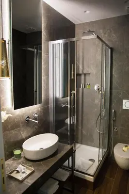 a bathroom with a glass shower and a sink at Unicum Roma Suites in Rome