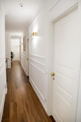 a hallway with a white door and wooden floors at Unicum Roma Suites in Rome