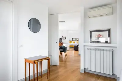 a living room with white walls and a table at Penthouse Rome Capitol in Rome