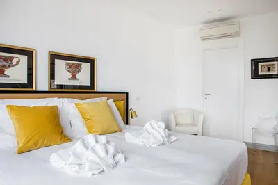 a bedroom with a white bed with yellow pillows at Penthouse Rome Capitol in Rome