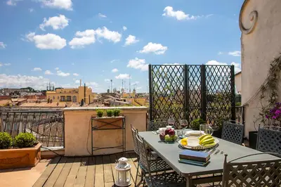 a table on a balcony with a view of a city at Penthouse Rome Capitol in Rome