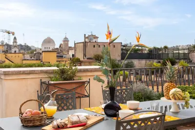 a table with food on a balcony with a view of the city at Penthouse Rome Capitol in Rome