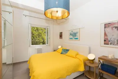 a bedroom with a yellow bed and a window at Lovely New Apartament, Viale Trastevere in Rome