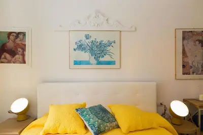 a bedroom with a bed with a yellow bedspread and two lamps at Lovely New Apartament, Viale Trastevere in Rome