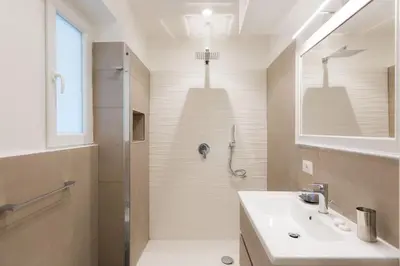a white bathroom with a shower and a sink at Lovely New Apartament, Viale Trastevere in Rome