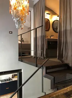 a staircase with a mirror and a chandelier at Boutique Loft steps from the Colosseum - Gio Roma in Rome