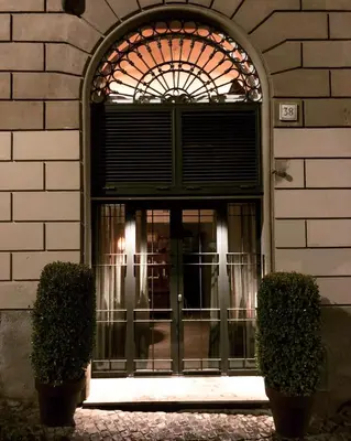 an entrance to a building with a window and two bushes at Boutique Loft steps from the Colosseum - Gio Roma in Rome