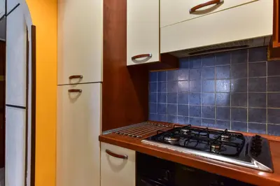 a kitchen with a stove top oven next to a refrigerator at Trastevere Queen in Rome