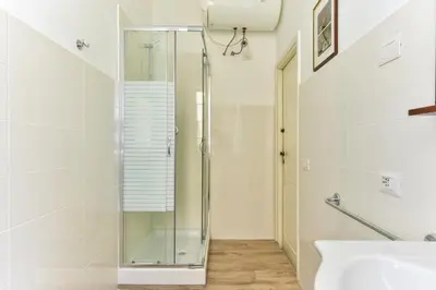 a glass shower in a bathroom with a sink at Trastevere Queen in Rome