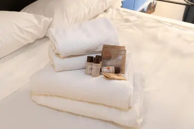 a pile of towels and cosmetics on a bed at POPOLO PEN 56 Apartament in Rome