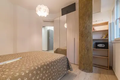 a small bedroom with a bed and a large window at Appartamenti Clivo di Monte del Gallo in Rome