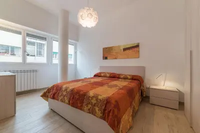 a white bedroom with a bed and a chandelier at Appartamenti Clivo di Monte del Gallo in Rome
