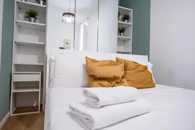 a white bed with white towels and a yellow pillow at Apartment by the Colosseum - White Chic Flats in Rome