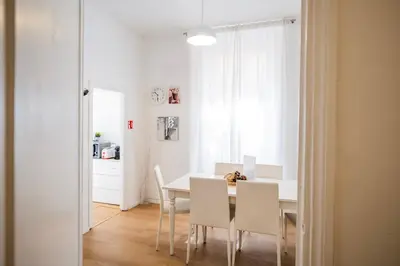 a white dining room with a table and chairs at Apartment by the Colosseum - White Chic Flats in Rome