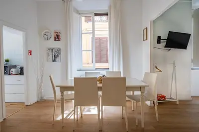 a kitchen and dining room with a table and chairs at Apartment by the Colosseum - White Chic Flats in Rome
